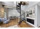 Bright, open living space featuring exposed stone and a spiral staircase that leads to a modern, stainless steel kitchen at 1500 River Mill Dr # 310, Wake Forest, NC 27587