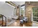 Open-concept living area boasting exposed stone walls, timber beams, hardwood floors, and plenty of natural light at 1500 River Mill Dr # 310, Wake Forest, NC 27587