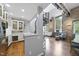 Living room featuring kitchen with spiral staircase, stone walls, hardwood floors, and lots of natural light from large windows at 1500 River Mill Dr # 310, Wake Forest, NC 27587