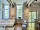 Bright living room featuring stone walls, hardwood floors, beamed ceilings, and lots of natural light from large windows at 1500 River Mill Dr # 310, Wake Forest, NC 27587
