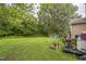 Backyard with some lawn maintenance equipment present and some woods at 1726 Morgantown Rd, Burlington, NC 27217