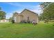 Side and rear view of house showing backyard with some tools and lawn maintenance equipment at 1726 Morgantown Rd, Burlington, NC 27217
