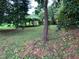 Lush backyard featuring a vine-covered pergola, mature trees, and well-maintained lawn at 1806 Rendall St, Burlington, NC 27215