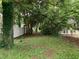 A serene backyard featuring mature trees, green grass, and a privacy fence, perfect for relaxing and outdoor activities at 1806 Rendall St, Burlington, NC 27215
