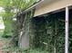 Exterior side view showing the house's foliage coverage at 1806 Rendall St, Burlington, NC 27215