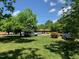 Residential street view showcasing a cozy home with manicured lawn and a mature tree adding charm to the neighborhood at 1806 Rendall St, Burlington, NC 27215