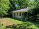 Charming single story home with a cozy front porch nestled amidst lush greenery and mature trees in a serene setting at 1806 Rendall St, Burlington, NC 27215