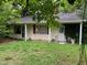 Charming bungalow-style home with a covered front porch, lush greenery, and a serene setting at 1806 Rendall St, Burlington, NC 27215