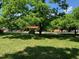 Street view of a neighborhood featuring a well-maintained lawn and mature trees, creating a park-like atmosphere at 1806 Rendall St, Burlington, NC 27215