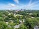 Aerial view showcases city skyline and lush tree coverage surrounding a neighborhood at 1904 Smallwood Dr, Raleigh, NC 27605