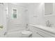Bright bathroom with white fixtures, a tub-shower, and tiled floor at 1904 Smallwood Dr, Raleigh, NC 27605