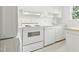 Clean kitchen with white appliances and a view to the outdoors from the window at 1904 Smallwood Dr, Raleigh, NC 27605