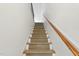 Carpeted staircase with wooden handrail leading to the upper level at 1904 Smallwood Dr, Raleigh, NC 27605