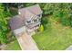 Aerial view of a home with a two-car garage, long driveway, green lawn, and mature trees at 210 Water Oak Way, Louisburg, NC 27549