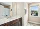 Bathroom with a large mirror, vanity with a white countertop, and a window offering natural light at 210 Water Oak Way, Louisburg, NC 27549