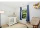 Bright Bedroom featuring a white crib, rocking chair, and natural light from the window at 210 Water Oak Way, Louisburg, NC 27549