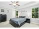Bright bedroom with neutral walls featuring a ceiling fan, tray ceiling, and natural light from the windows at 210 Water Oak Way, Louisburg, NC 27549