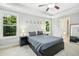 Bright bedroom features a tray ceiling, ceiling fan, and moon phase wall art, alongside sunny windows at 210 Water Oak Way, Louisburg, NC 27549