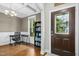 Inviting entryway featuring hardwood floors, wainscoting, and a decorative front door, leading into a cozy office space at 210 Water Oak Way, Louisburg, NC 27549