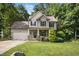 Charming two-story home with a manicured lawn, attached garage, and a mix of stone and siding accents at 210 Water Oak Way, Louisburg, NC 27549