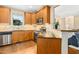 This kitchen has stainless steel appliances, wood cabinets, granite countertops, and an open view to the living area at 210 Water Oak Way, Louisburg, NC 27549