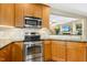 Well-lit kitchen features stainless steel appliances and granite countertops, with a pass-through to the living area at 210 Water Oak Way, Louisburg, NC 27549