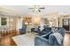 Open-concept living space with hardwood floors, a large sectional sofa, and seamless flow to the dining and kitchen areas at 210 Water Oak Way, Louisburg, NC 27549