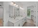 Bright bathroom featuring a double sink vanity, modern lighting, and a walk-in closet at 2124 Country Air Ln, Hillsborough, NC 27278