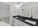 Bathroom with double vanity, black countertop, white cabinets, and stylish fixtures at 2124 Country Air Ln, Hillsborough, NC 27278