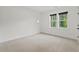 Bright bedroom featuring neutral carpet, two windows, and white walls at 2124 Country Air Ln, Hillsborough, NC 27278