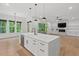 Open-concept kitchen with an island, stainless appliances, and hardwood flooring at 2124 Country Air Ln, Hillsborough, NC 27278