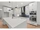 Modern kitchen with white cabinets, stainless steel appliances, and a large center island with quartz countertop at 2124 Country Air Ln, Hillsborough, NC 27278