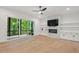 Bright living room with hardwood floors, fireplace, built-ins, and sliding door access to the porch at 2124 Country Air Ln, Hillsborough, NC 27278