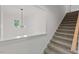 Carpeted stairs with white walls lead to the upper level, next to bright landing with window at 2124 Country Air Ln, Hillsborough, NC 27278