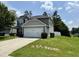 Two-story gray home with a two-car garage and a well-manicured lawn at 219 Trimble Dr, Elon, NC 27244