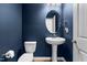 Stylish blue half bath with pedestal sink, toilet, mirror, and brushed nickel fixtures at 222 Oak Branch - Lot 72 Trl, Garner, NC 27529
