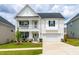 Charming two-story home with covered porch, rocking chairs, lush lawn, and two car garage at 222 Oak Branch - Lot 72 Trl, Garner, NC 27529