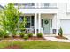 Inviting front porch with rocking chairs and a beautifully landscaped garden area at 222 Oak Branch - Lot 72 Trl, Garner, NC 27529