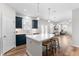 Contemporary kitchen featuring dark blue cabinets, a white island with seating, and modern lighting at 222 Oak Branch - Lot 72 Trl, Garner, NC 27529