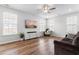 Bright living room featuring hardwood floors, a ceiling fan, television, and large windows providing lots of light at 222 Oak Branch - Lot 72 Trl, Garner, NC 27529