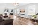 Open-concept living room with hardwood floors, a ceiling fan, and abundant natural light from multiple windows at 222 Oak Branch - Lot 72 Trl, Garner, NC 27529
