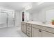 Bright bathroom featuring a double sink vanity, a large mirror, walk in shower, and neutral tile at 222 Oak Branch - Lot 72 Trl, Garner, NC 27529