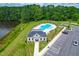 Aerial view of community pool, clubhouse, parking, and pond surrounded by green trees and grass at 222 Oak Branch - Lot 72 Trl, Garner, NC 27529