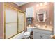 A cozy bathroom featuring a shower with a gold frame, a decorative mirror, and a toilet with storage at 2333 Grey Gables Dr, Burlington, NC 27215