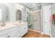 Bright bathroom with double vanity, decorative mirror, and glass-enclosed shower with decorative tile at 2333 Grey Gables Dr, Burlington, NC 27215