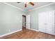A neutral-toned bedroom with a ceiling fan, light hardwood floors, and ample closet space at 2333 Grey Gables Dr, Burlington, NC 27215