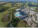An aerial view showcases the community's pool, clubhouse, golf course and surrounding lush landscapes at 236 Lucky Ribbon Ln, Holly Springs, NC 27540