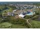 Expansive aerial view shows community with lush golf course, clubhouse, pool, and well-maintained residences at 236 Lucky Ribbon Ln, Holly Springs, NC 27540