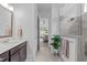Well-lit bathroom featuring a walk-in shower with glass door and a view into the bedroom at 236 Lucky Ribbon Ln, Holly Springs, NC 27540