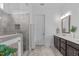 Bright bathroom with a tiled walk-in shower, double vanity, and updated lighting at 236 Lucky Ribbon Ln, Holly Springs, NC 27540